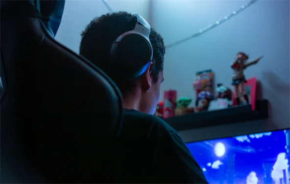 Poika istuu tietokoneen ääressä pelaamassa