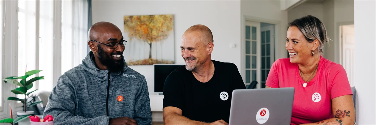 A group of people sitting at a table using a laptop