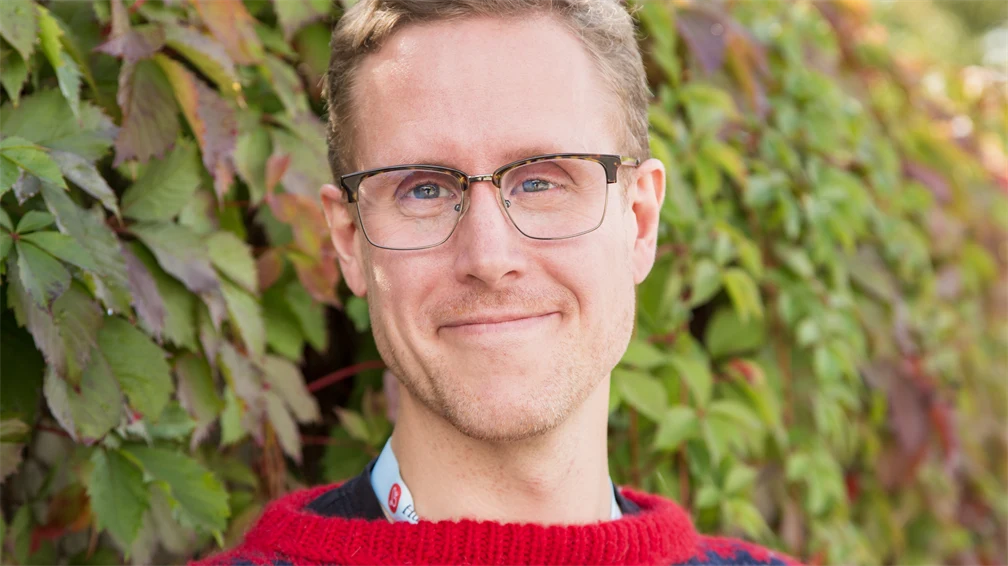 Smilende portrett av mann med briller i Mariusgenser