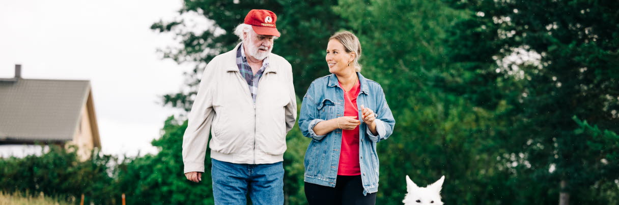 Two people and a dog go for a walk.