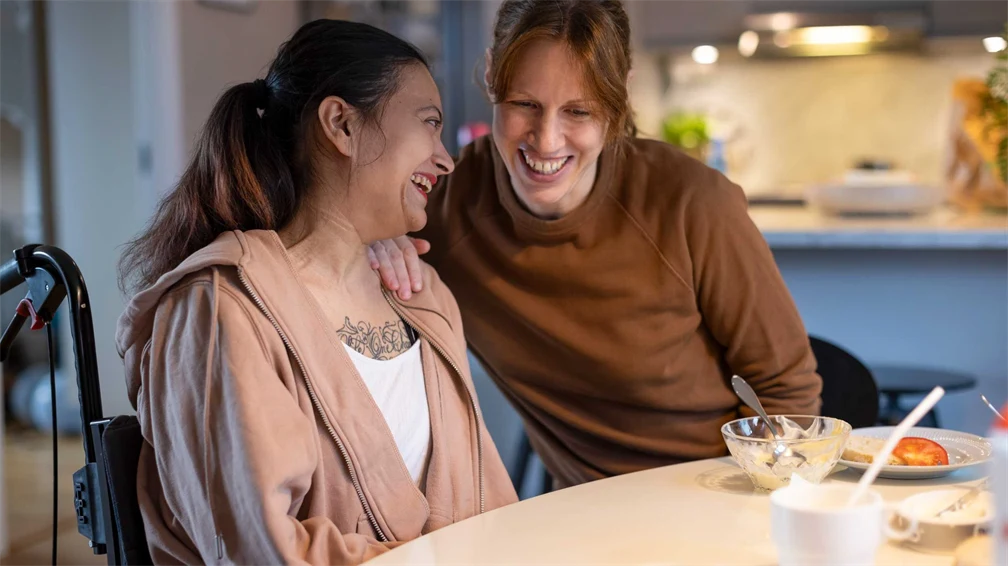 Två kvinnor sitter vid matbord