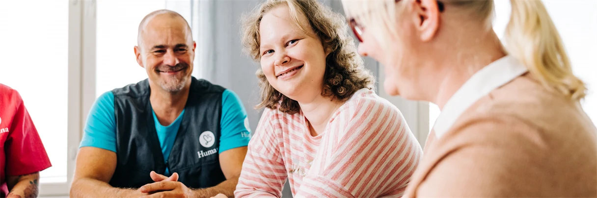 Ryhmä ihmisiä kokouksessa pöydän äärellä.
