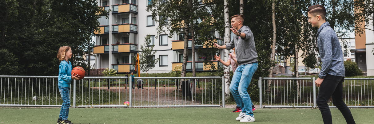 Three people playing basketball on artificial grass.