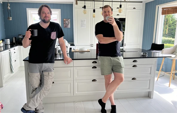 Svein og Anders står på kjøkkenet med hver sin kaffekopp