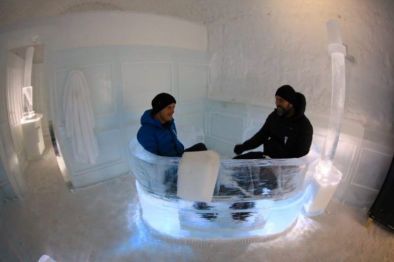 Två personer sitter i ishotells badkar
