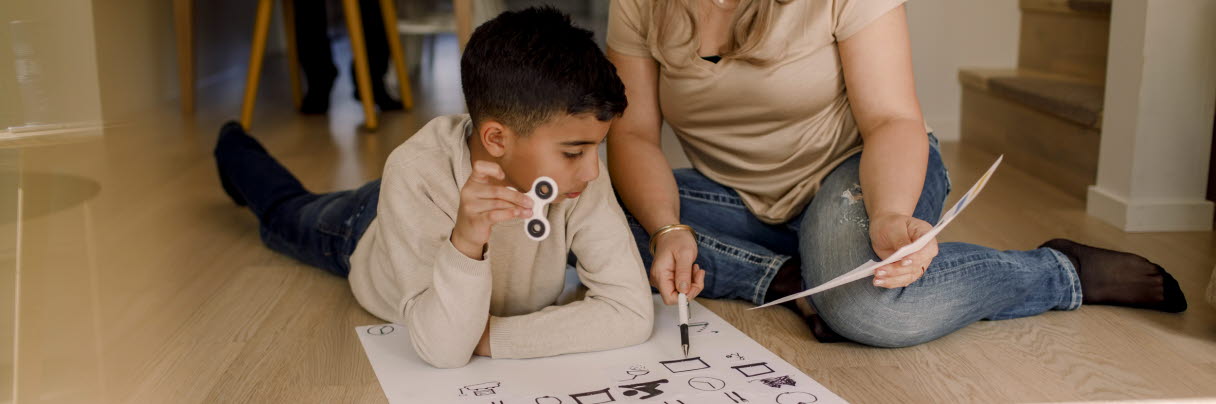 Kvinna lär barn med funktionsvariation med hjälp av schema och teckenstöd