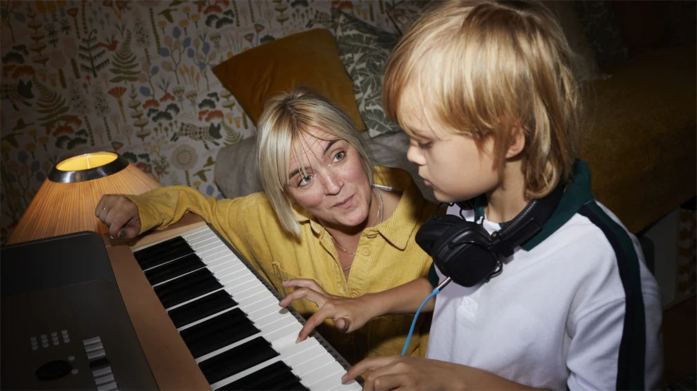 En pojke och mamma spelar piano 