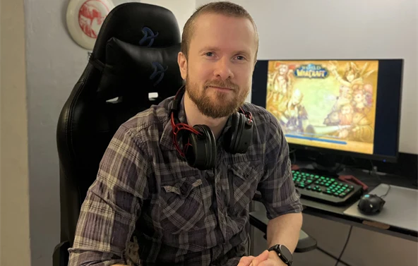 Gamingkontakt Tobias smiler til kamera foran dataskjermen sin