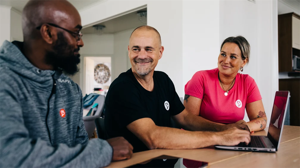 Tre Humana-anställda ler mot varandra.