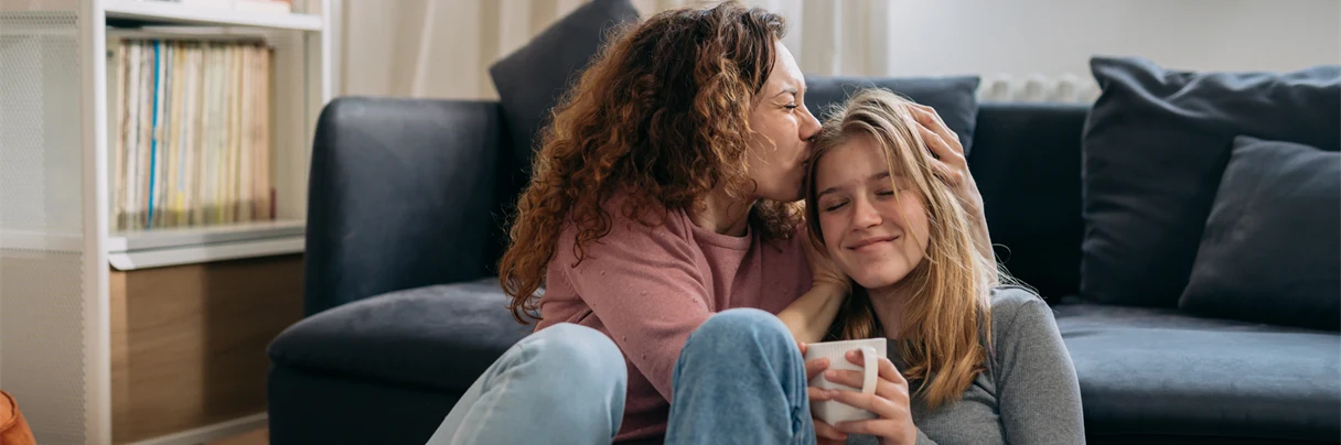 Kvinne klemmer jente som smiler