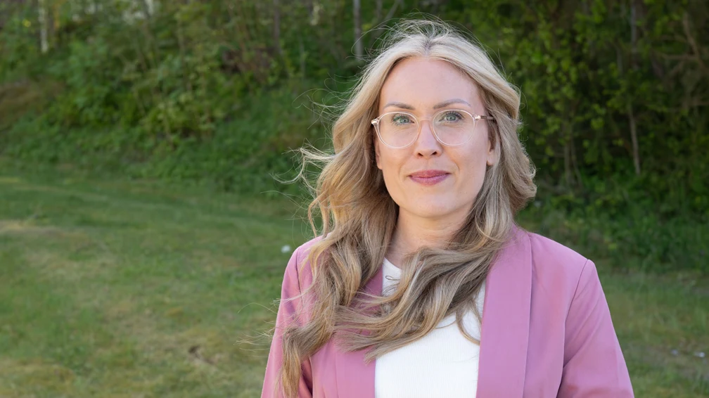 Kvinna med blont hår som ler.