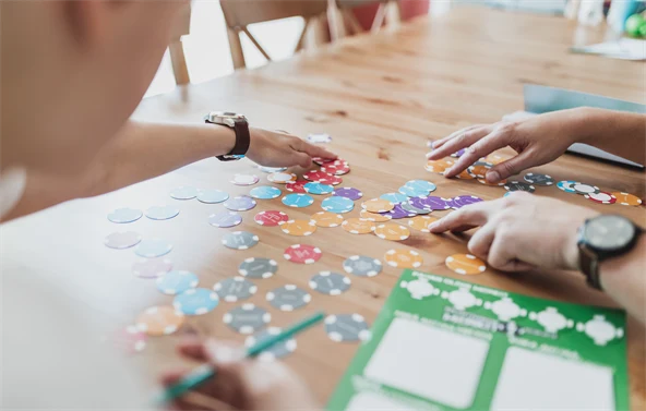 Henkilö pelaamassa peliä pöydän ääressä.