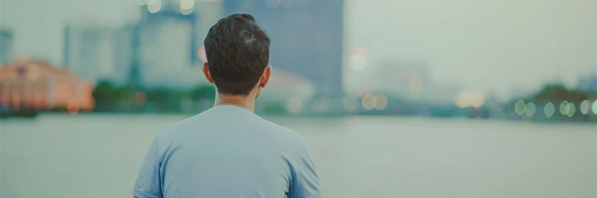 En man i grå t-shirt blickar bort från kameran.