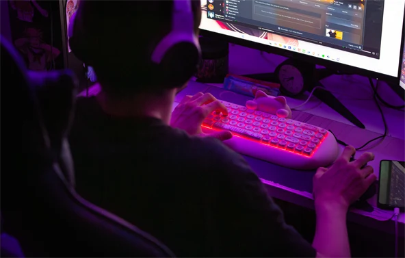 Poika istuu tietokoneen ääressä pelaamassa